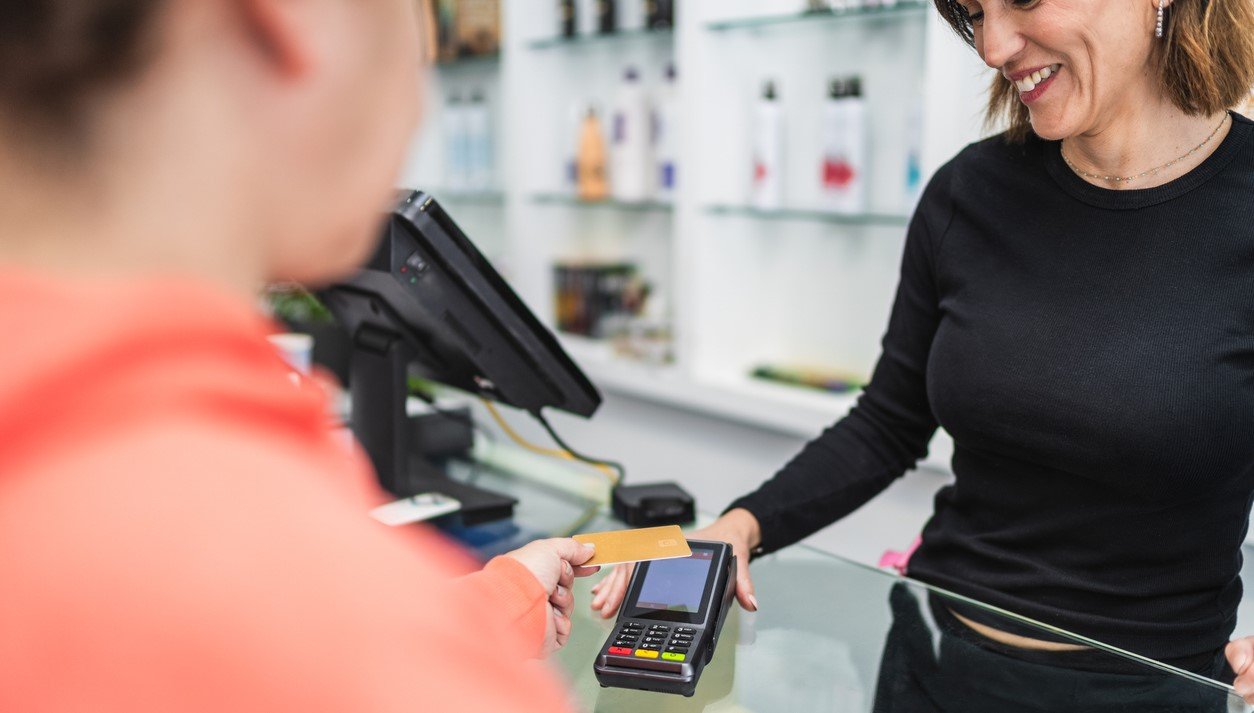 Eine Kundin zahlt an der Kasse für ihren Coiffeurbesuch.