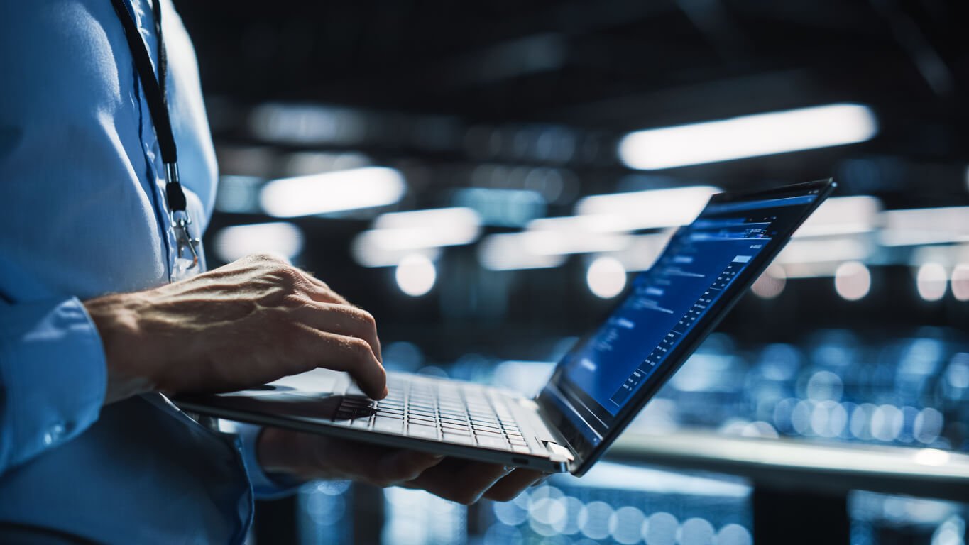 Person arbeitet an Laptop in Büroräumlichkeit